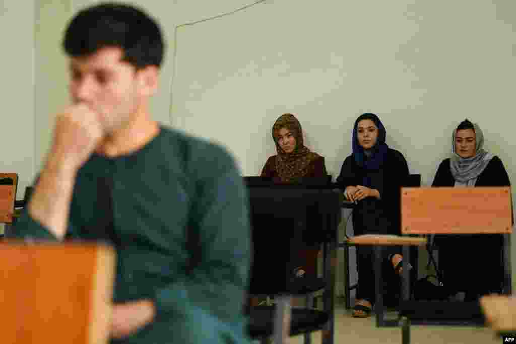 Students listen to a lecture at a private university in Kabul on September 6. The Taliban has decreed that students must be segregated by gender. Other photos from Kabul show male and female students separated by a curtain. &nbsp;