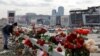 A woman lays flowers near the Crocus Concert Hall near Moscow, where a deadly shooting attack killed more than 140 people. 