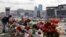 A woman lays flowers near the Crocus Concert Hall near Moscow, where a deadly shooting attack killed more than 140 people. 