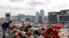 Russia - A woman lays flowers on the roadside in front of the burnt-out Crocus City Hall on the outskirts of Moscow, March 26, 2024. 