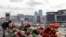 Russia - A woman lays flowers on the roadside in front of the burnt-out Crocus City Hall on the outskirts of Moscow, March 26, 2024. 