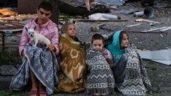 Copii adunați lângă locul unui atac cu rachete rusești la Kiev, pe 28 august.