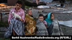 Copii adunați lângă locul unui atac cu rachete rusești la Kiev, pe 28 august.