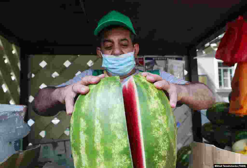 A seller cuts a watermelon in half in Moscow. (TASS/Mikhail Tereshchenko)