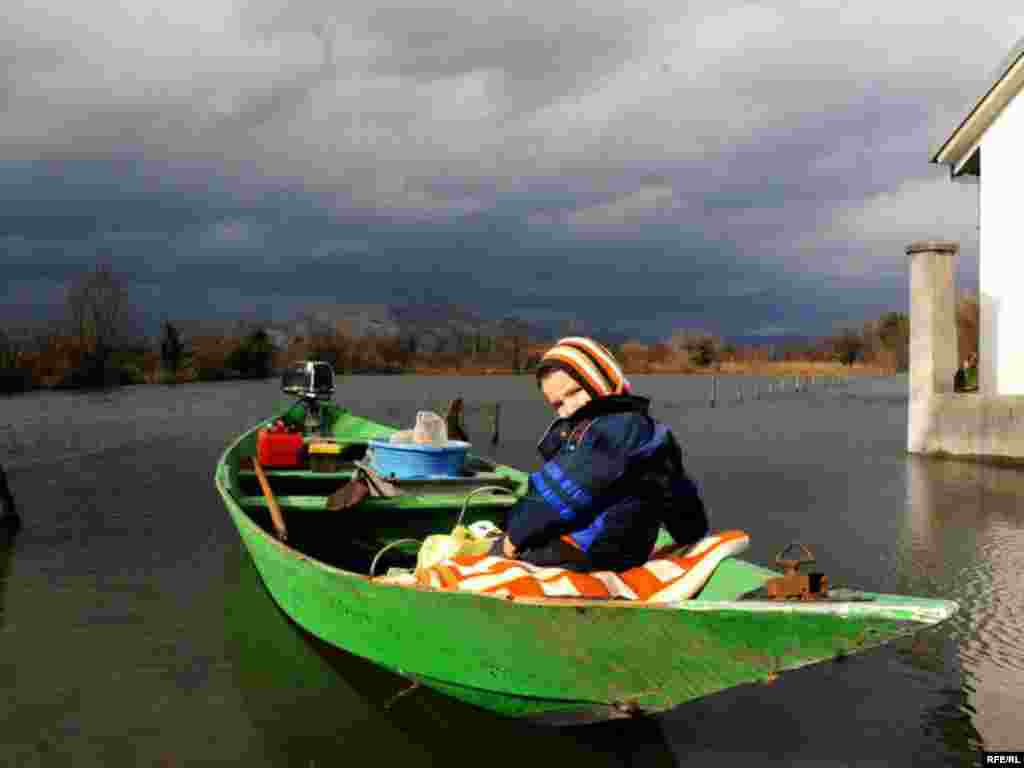 A child prepares to flee a flooded home in Kurilo, Montenegro. - Photo by Savo Prelevic for RFE/RL