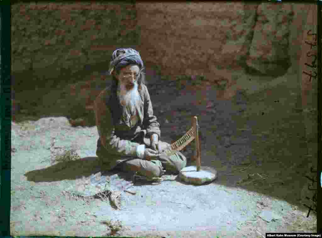 A goldsmith at work in a mud-walled courtyard in Kabul. These 1928 images, made by photographer Frederic Gadmer, form part of the Archives of the Planet project, which aimed to capture the world with large-format color photographs.