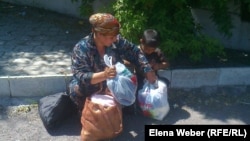 Женщина из малоимущей семьи упаковывает пакеты с вещами, которые она взяла на ярмарке. Темиртау, 29 мая 2013 года.