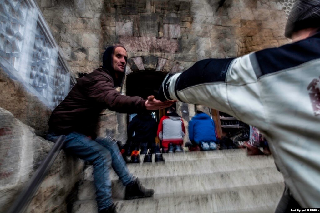 Alms-giving on the steps of the Sinan Pasha mosque in Prizren. The project called for photos that captured "the essence and variety of what it means to live in Kosovo that day." (Photo by Isuf Bytyçi)