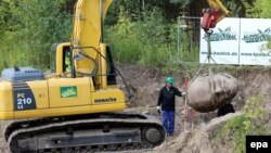 Жұмысшылар Ленин ескерткішінің бас бөлігін қайта қазып алып, жүк көлігіне тиеп жатыр. Германия, 10 қыркүйек 2015 жыл.