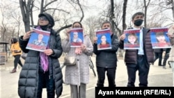 Активисты с портретами женщин, которых правозащитники внесли в список политических заключенных. Алматы, 8 марта 2021 года.