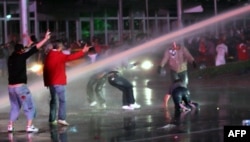 Protesters take cover from water cannons during clashes with police in Ankara on June 8.