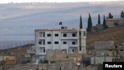 Флаг группировки "Исламское государство" над зданием в сирийском городе Кобани.