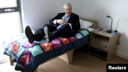 Мэр Лондона Борис Джонсон проверяет мягкость кроватей в Олимпийской деревне накануне Олимпийских игр в 2012 году