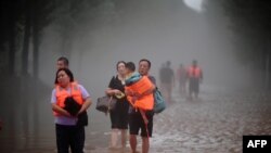 Fotografi e 1 gushtit, kur disa njerëz janë evakuuar nga provinca Hubei, për shkak të shirave të rrëmbyeshëm.
