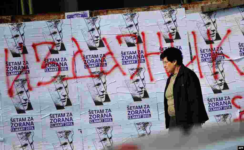 A woman walks past placards announcing the commemorative march in the Serbian capital to mark the 10th anniversary of Djindjic&#39;s assassination. (AFP/Andrej Isakovic)