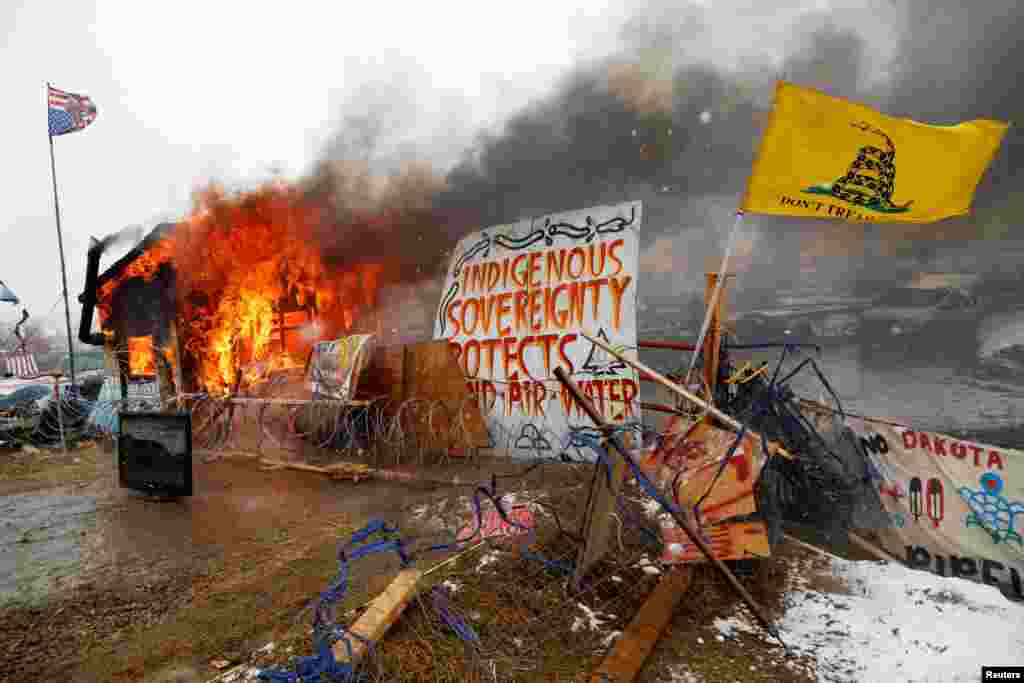 A structure burns after being set alight by protesters preparing to evacuate the main opposition camp against the Dakota Access oil pipeline near Cannon Ball, North Dakota. (Reuters/Terray Sylvester)