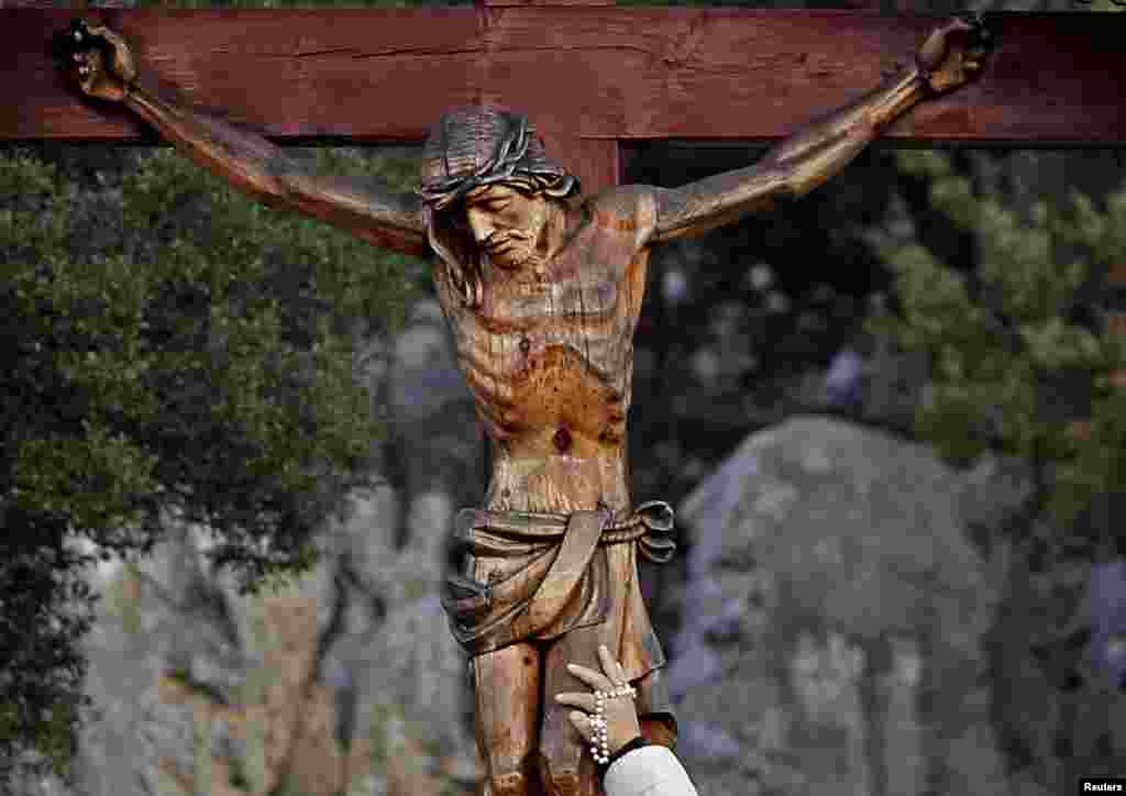 A woman touches a crucifix at the site where the Virgin Mary reportedly appeared in an apparition in Medjugorje, south of Sarajevo, Bosnia. (Reuters/Dado Ruvic)
