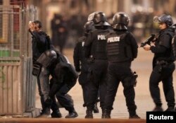 French spolice stop and search a local resident as shots are exchanged in Saint-Denis, France, near Paris, on November 18.