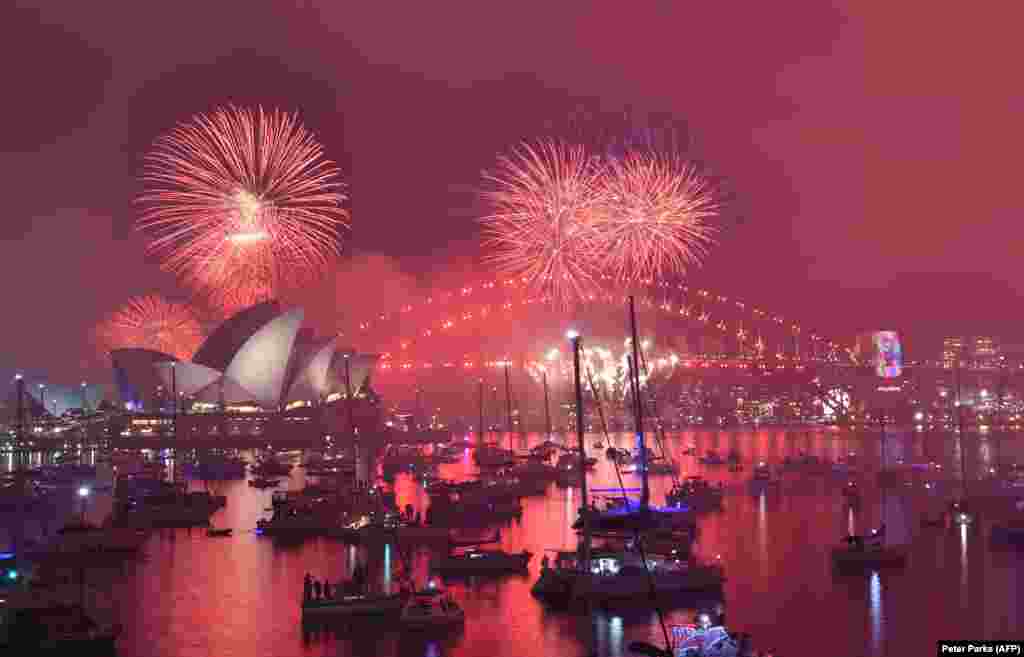 Fireworks explode over the Harbour Bridge and Opera House during a traditional early family fireworks show held before the main midnight event in Sydney, Australia, on December 31. (AFP/Peter Parks)​