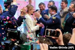 Ukraine's president-elect Volodymyr Zelenskiy and his wife, Olena Zelenska, greet their supporters at his headquarters after his election victory on April 21.