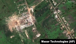Спутниковый снимок Maxar Technologies, на котором виден 40-метровый кратер и разрушенные здания в селе Довгенькое на Харьковщине, северо-западнее города Славянска Донецкой области, 6 июня 2022 года