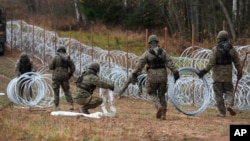 Polish soldiers lay razor wire along Poland's border with the Russian exclave of Kaliningrad in November 2022.