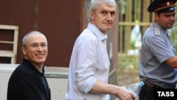 Former Yukos chief Mikhail Khodorkovsky (left) and Platon Lebedev are escorted to Moscow's Khamovniki district court on August 19.