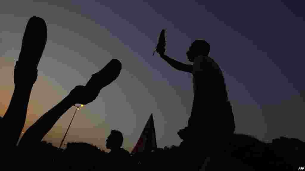 Egyptian antimilitary protesters wave their shoes as they demonstrate in Cairo&#39;s Tahrir Square. (AFP/Mohammed Abed)