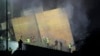 Rescuers gather as smoke rises from a collapsed building at the site of an Israeli air strike in Beirut's southern suburbs on September 27.