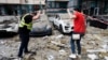 Damaged cars are seen outside an apartment building following a Russian missile attack in Kyiv on June 24.