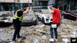 Damaged cars are seen outside an apartment building following a Russian missile attack in Kyiv on June 24.