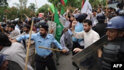 Protesters scuffle with Pakistani riot police as they attempt to reach the U.S. Embassy in Islamabad during a demonstration against the anti-Islam film "Innocence of Muslims."