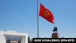Флаг Кыргызстана и памятник Манасу на главной площади Бишкека «Ала-Тоо». 30 июля 2020 года.