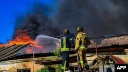 Пожежники гасять пожежу на складі після російського обстрілу в Херсоні, вересень 2023 року 