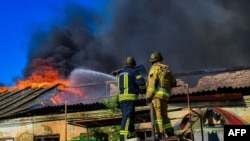 Пожарные тушат пожар на складе после обстрела в Херсоне.