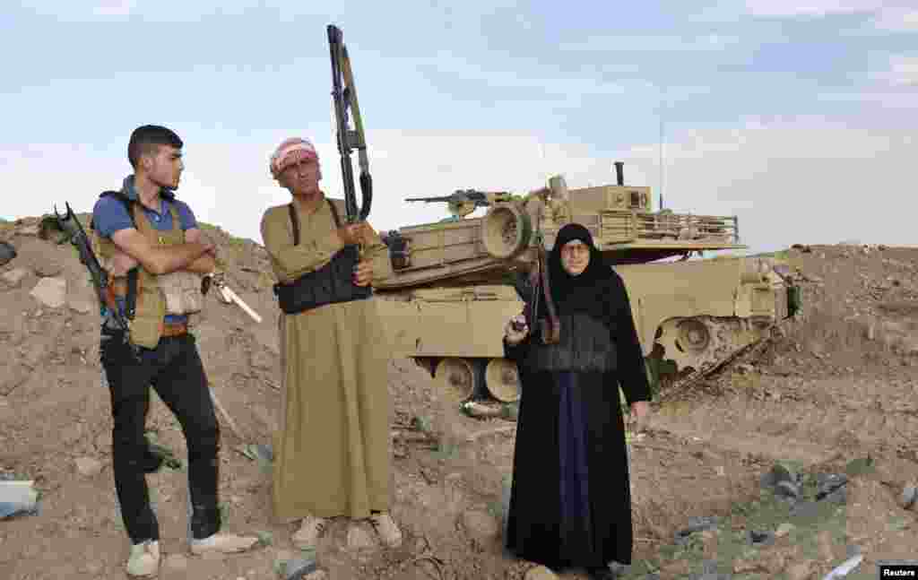 Un Muayad (right) a Ramadi resident fighting alongside tribal fighters, poses with her fellow fighters during clashes with the Al-Qaeda-linked Islamic State of Iraq and the Levant in Ramadi &nbsp;on May 19. (Reuters)