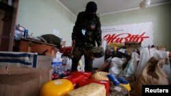 An armed pro-Russian militiaman from the Vostok Batallion looks at items that, according to him, were looted by other separatist groups and stored in the Donetsk regional administration building on May 29.