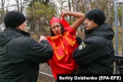 Ukrainian police detain a topless Femen activist during a protest in Kyiv in November 2017.