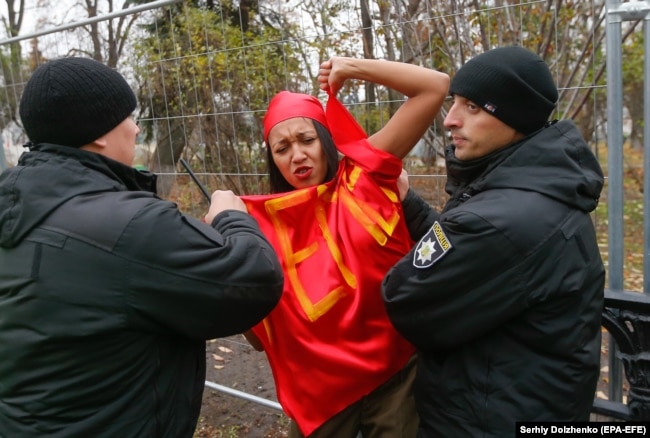 Ukrainian police detain a topless Femen activist during a protest in Kyiv in November 2017.