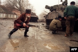Чачэнскі добраахвотнік хаваецца за рускім танкам падчас вулічных баёў у Грозным.