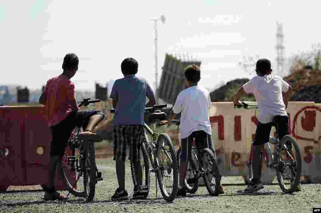 Israeli boys watch a battery of Iron Dome, a short-range missile-defense system, positioned on the outskirts of Tel Aviv. (AFP/David Buimovitch)