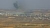 Smoke rising above buildings during reported Syrian and Russian air strikes in Syria's southeastern Quneitra province, July 16, 2018