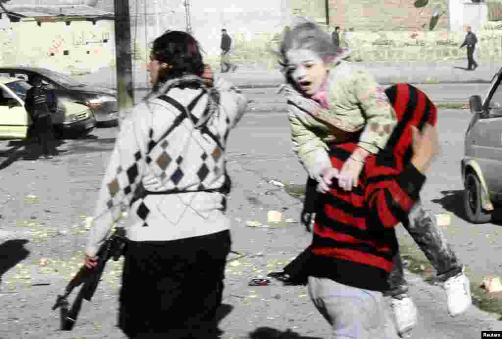 A man carries a wounded girl who survived what activists say was an air strike by government forces in Aleppo's Al-Ansari al-Sharqi neighborhood on December 9. (Reuters/Ammar Abdullah)