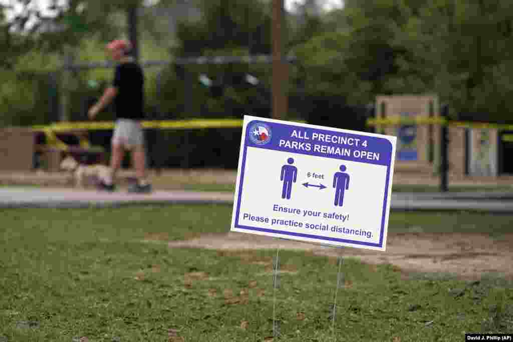 A sign is posted in a Houston park reminding people to practice social distancing. A stay-at-home order was issued on March 24 for Houston and Harris County residents to help fight the spread of COVID-19.&nbsp;