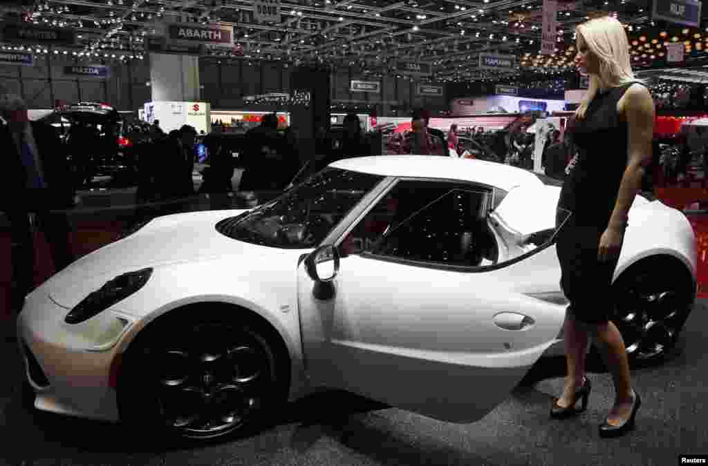 A model stands next to the Alfa Romeo 4C.