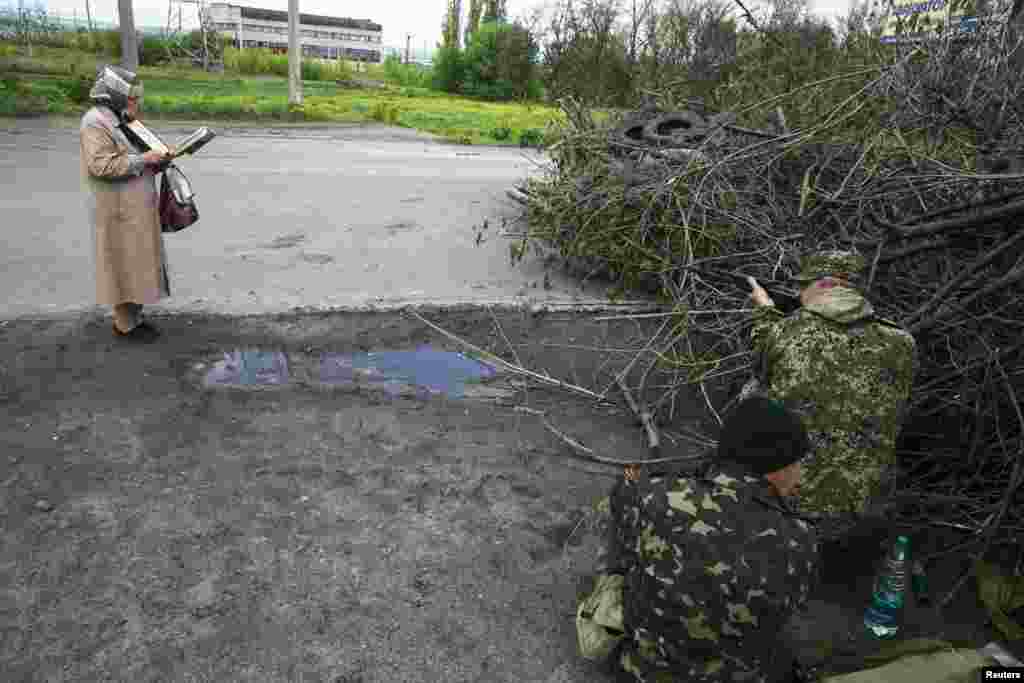 A woman reads the Bible as pro-Russia armed men take up positions near the eastern Ukrainian town of Slovyansk on May 5. (Reuters/Baz Ratner)