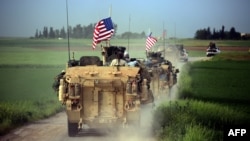 U.S. forces, accompanied by Kurdish People's Protection Units (YPG) fighters, drive their armored vehicles near the northern Syrian village of Darbasiyah, on the border with Turkey, last month.