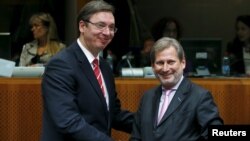 Serbian Prime Minister Aleksandar Vucic (left) posing with European Neighborhood Policy and Enlargement Negotiations Commissioner Johannes Hahn at the start of a European Union-Serbia accession conference in Brussels on December 14.