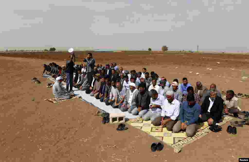 Turkish Kurds perform their Friday Prayers in solidarity with the people of Kobani in an open field near the southeastern Turkish town of Suruc in Sanliurfa Province close to the border between Turkey and Syria. The UN envoy for Syria called on Turkey to allow volunteers to cross the Syrian border to prevent Islamic State fighters carrying out a massacre in Kobani. (Reuters/Umit Bektas)