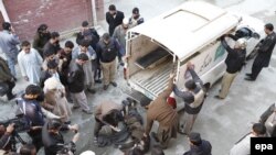 Полиция увозит тело одного из нападавших на университет в Чарсадде, Пакистан, 20 января 2016 года.